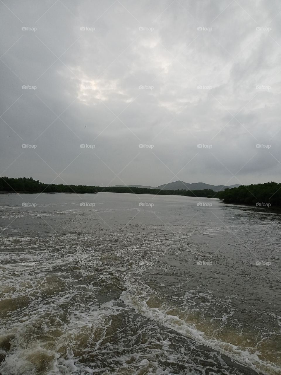 Beautiful view of the river in sunset time with heavy rainfall with nice background of mountain cloudy sky it's looking nice