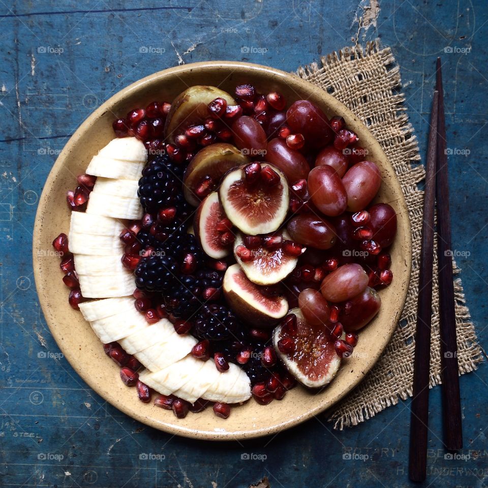 Fresh fruit on plate sitting on old blueprint table. 
