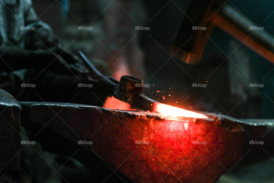 axe. iron axe being moulded by heating and beating it.