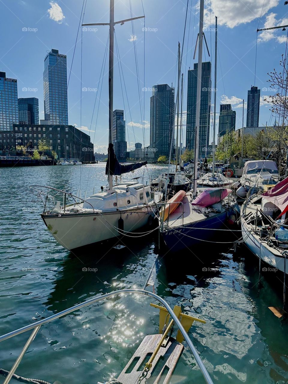 This is „Newtown Creek“ by the „Pulaski Bridge“ in LIC, Queens with its variety of pretty boats in the late afternoon around the golden hour when the setting sun is strongest and most reflective on the water. 2024. Hypnotic Productions