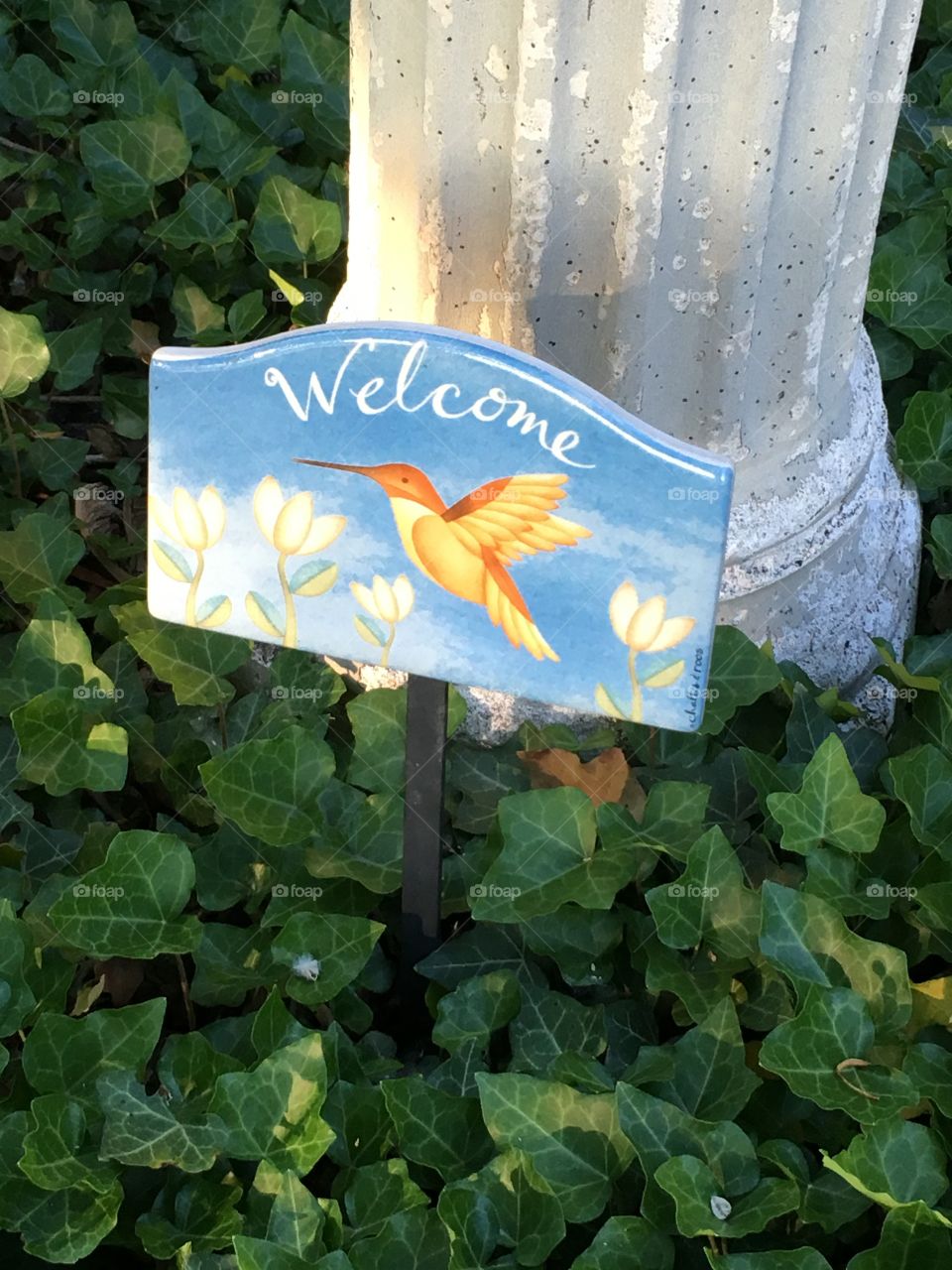 Welcome Sign with bird on it outside the house in front yard