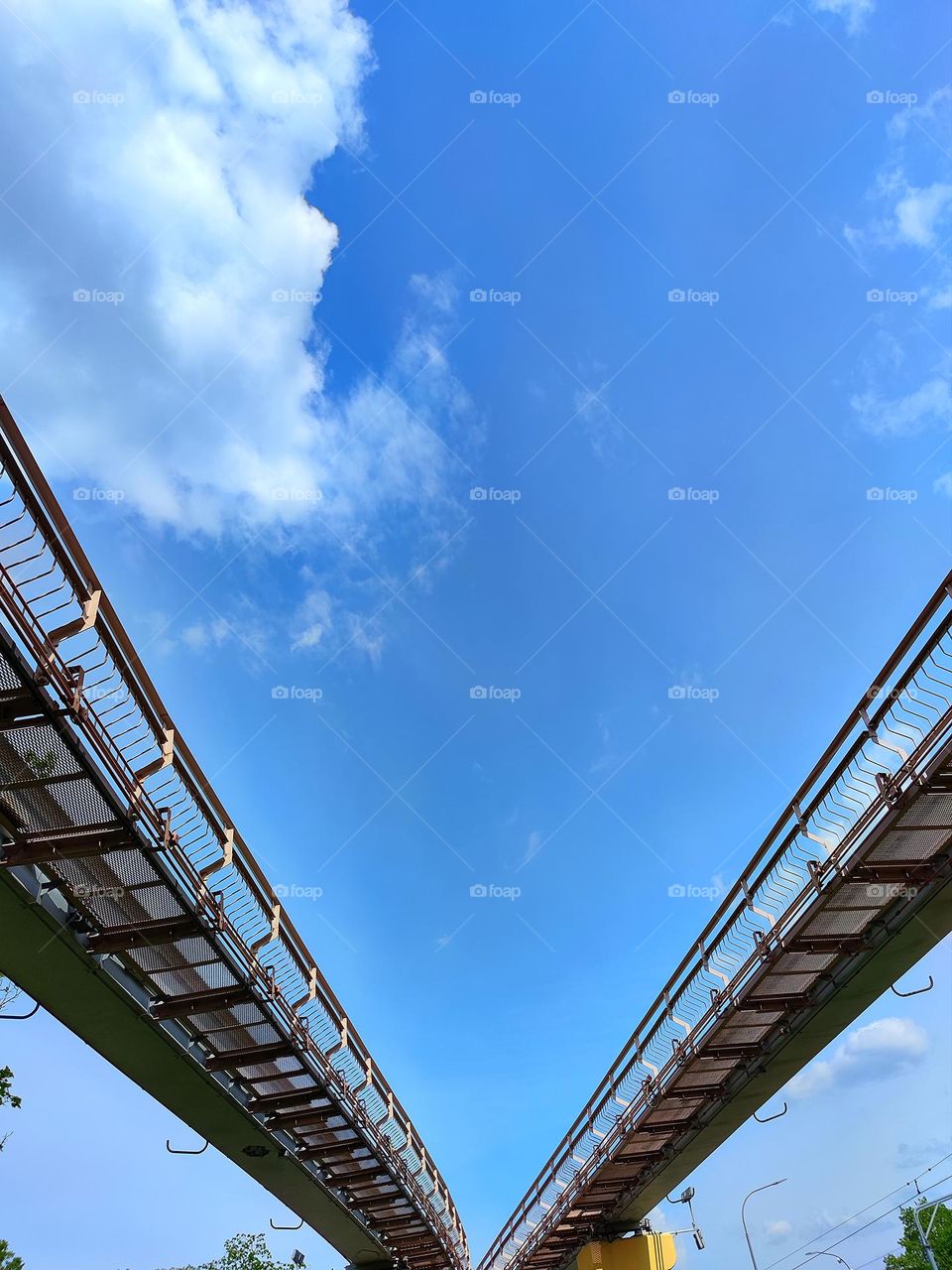 Monorail road against a blue sky with white clouds.  View from above.