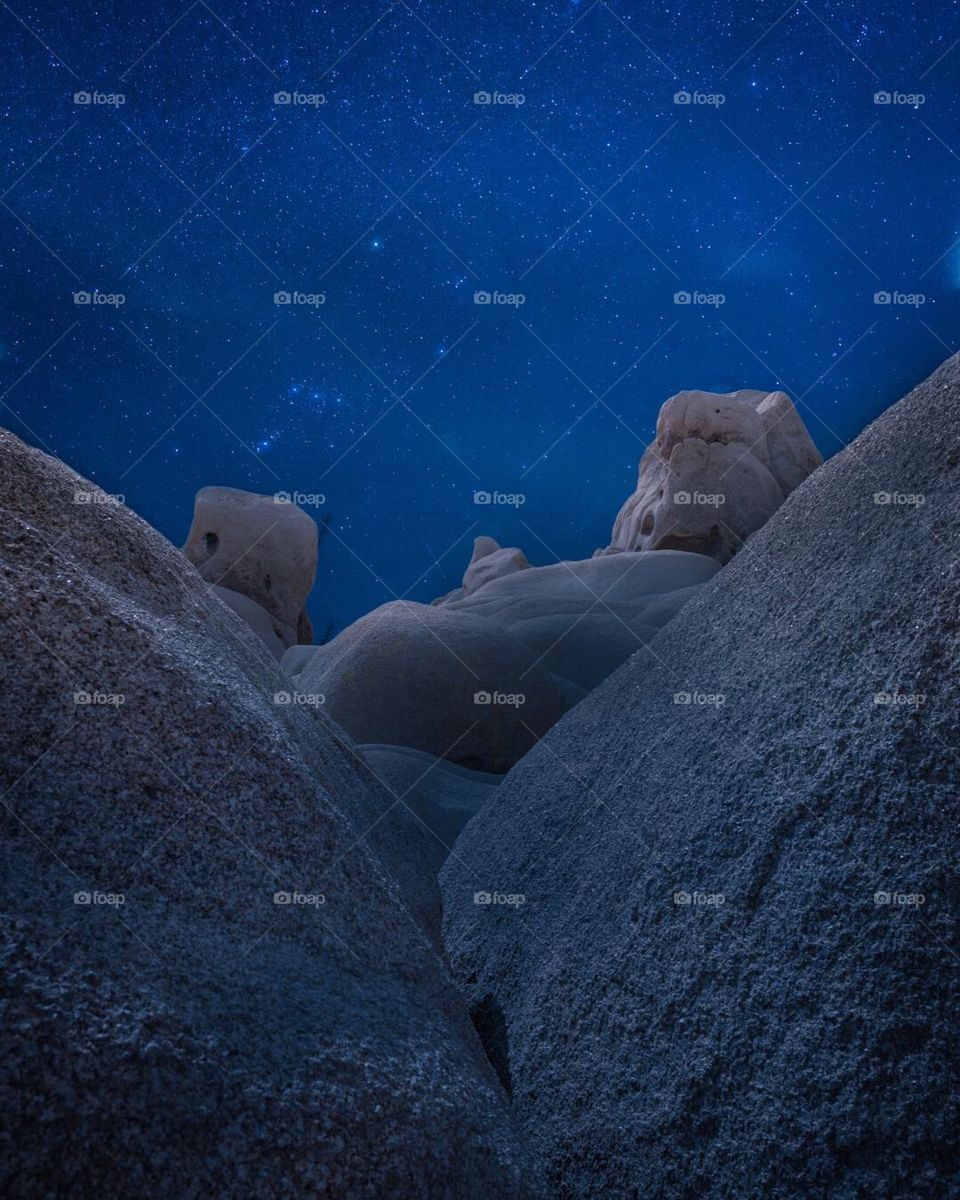 Twilight starry sky over desert rock formations and boulders 