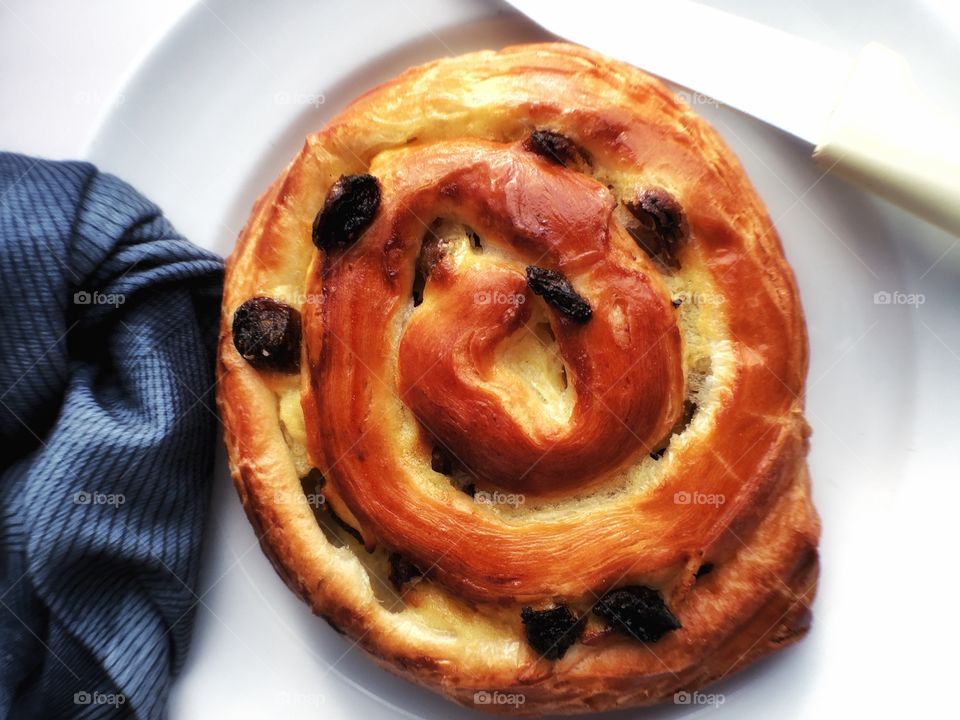 Spiral shaped pastry on plate with serviette 