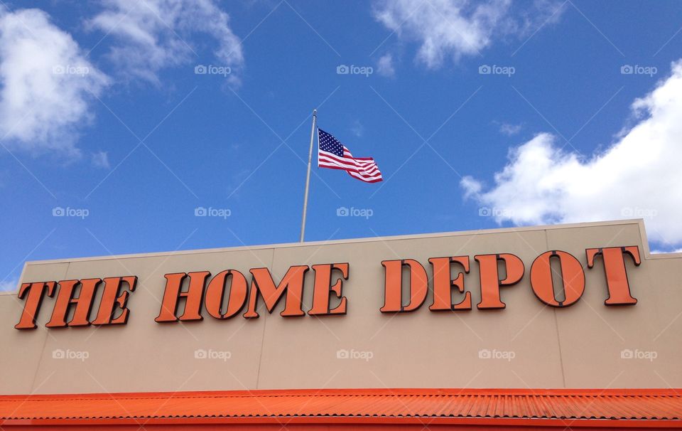 Home Depot loves America . USA flag flying over Home Depot in blue skies