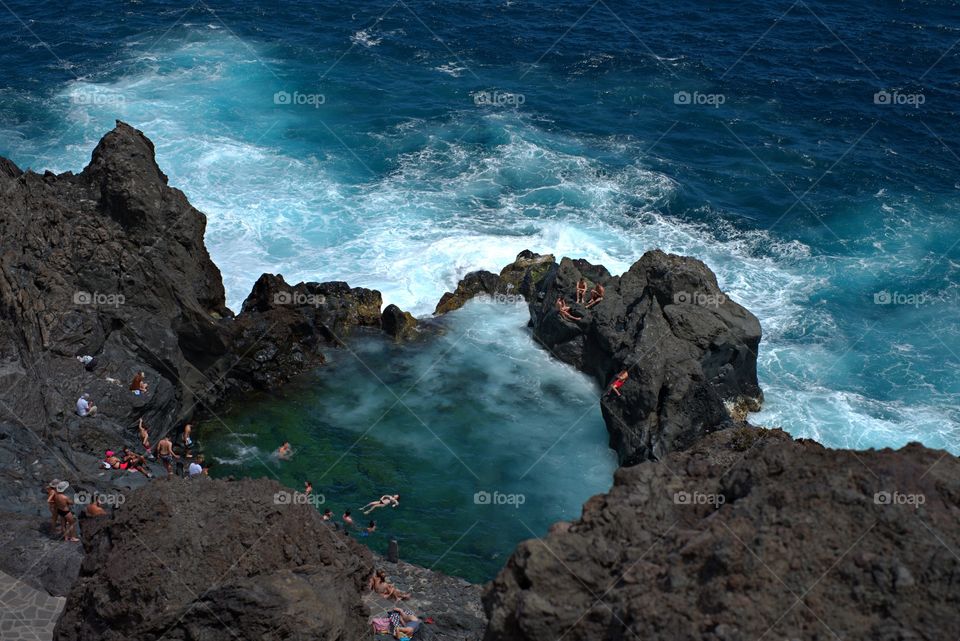 A natural spa in La Laja natural rock pool of a volcanic origin surrounded by the intense blue of the Atlantoc Ocean. Tenerife, Canary Islands.