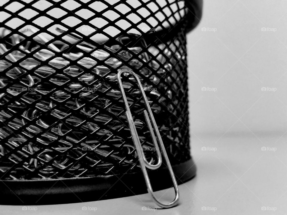 A sole paper clip makes its way out of the cage in order to avoid being chosen for hard labor!