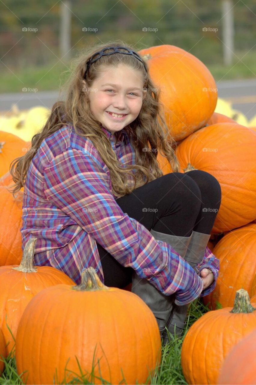 Girl sitting in pumpkins