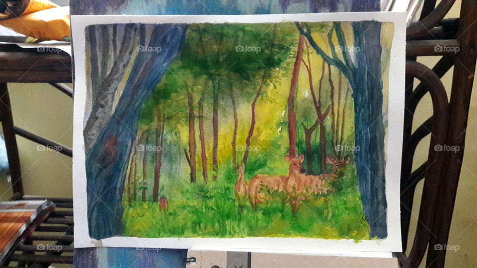 Deers playing peeka a boo in the Nature Park. The elders aware, little one busy eating.