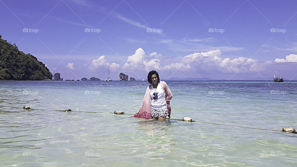 Portrait Asian woman Standing in the sea of clear skies at krabi in Thailand