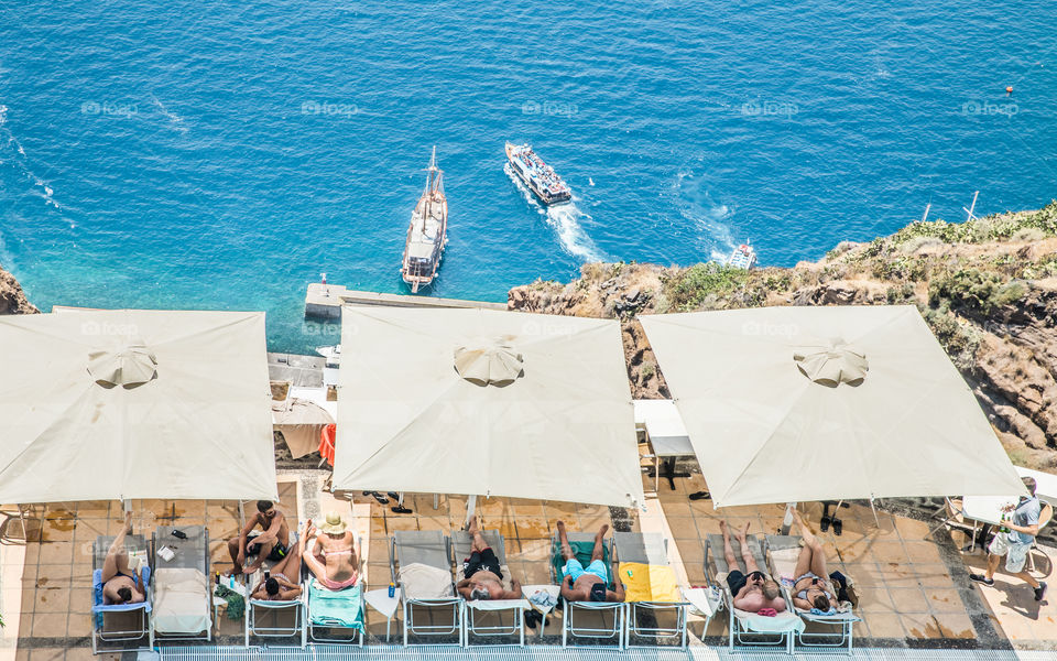 People Enjoying Vacation In A Hotel Resort With Sea View On Famous Greek Island Santorini