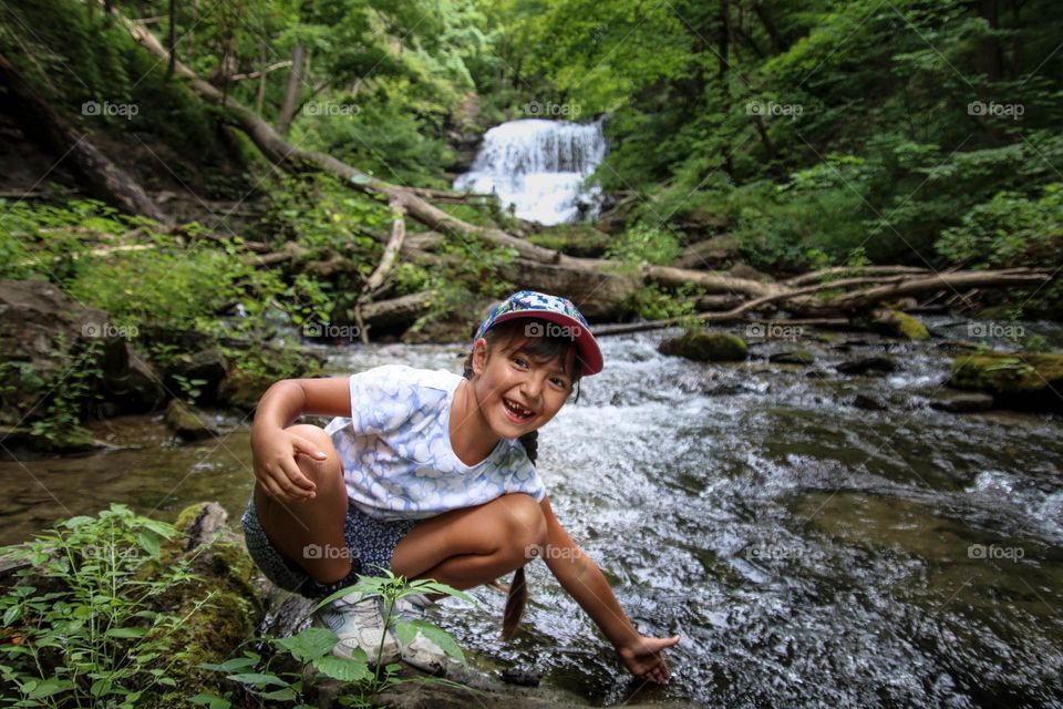 Happy little girl on a hike by the river