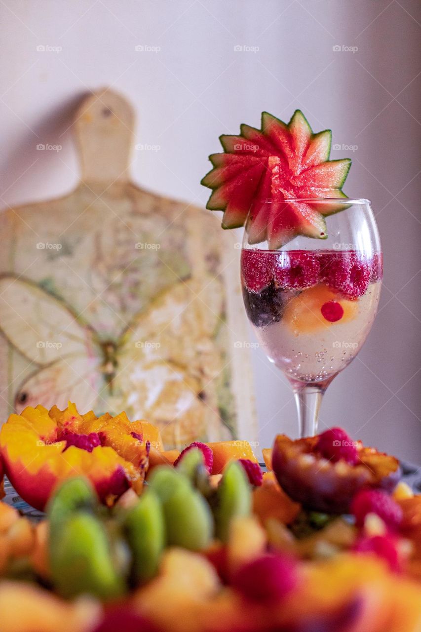 A fruit salad and the glass of aqua mineral water