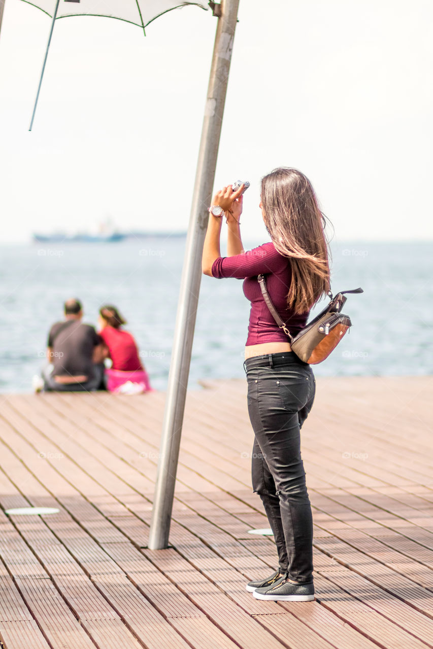 Young Woman Taking A Photograph With Mobile Phone
