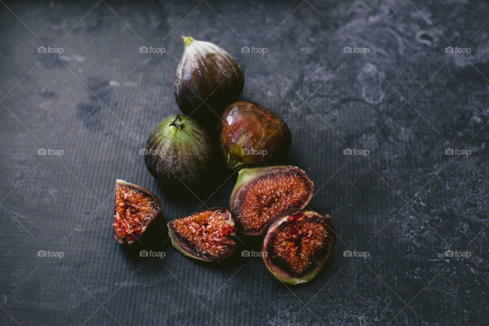 Figs, whole and sliced on kitchen granite bench 