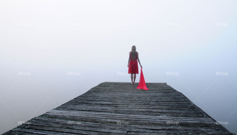 foggy morning at the lake in polish countryside  and red dress