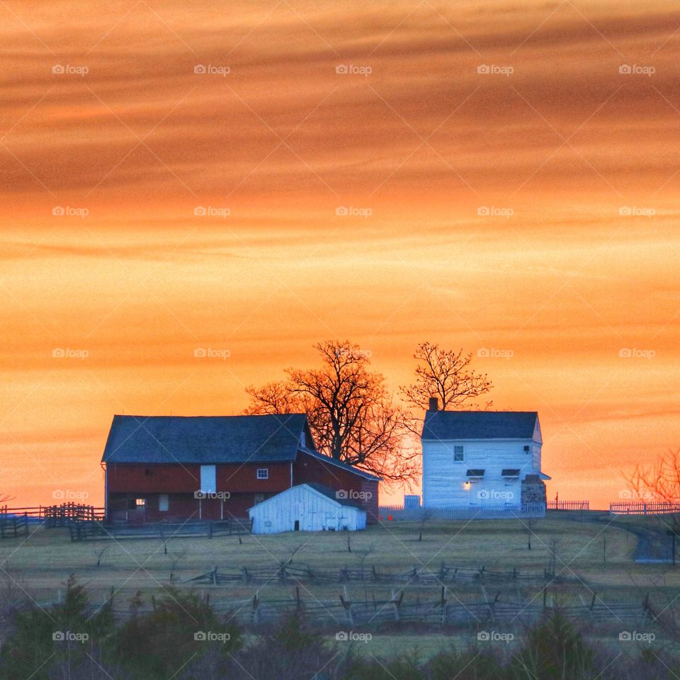 small rural farm at sunset