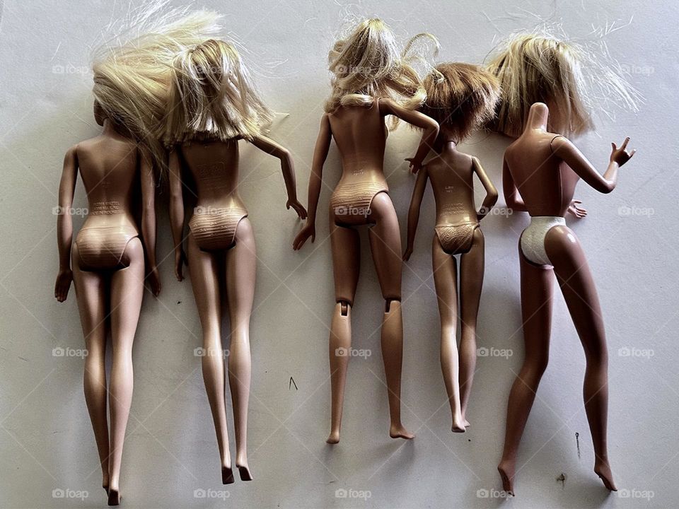 Some Barbie dolls back view on foam core board