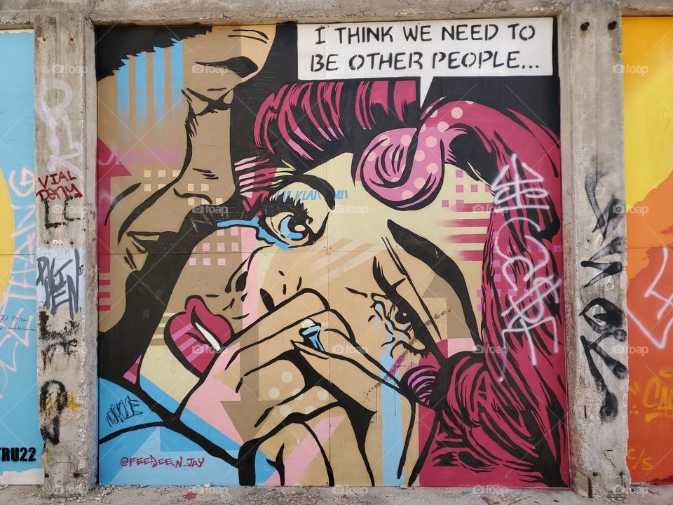 I spotted various shades of pink on this comic book style outdoor street art gallery mural of a man and a woman.