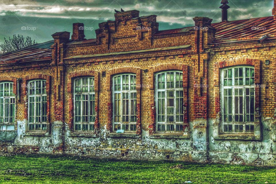 old red brick building. framed large white windows and a geometric pattern on the facade.