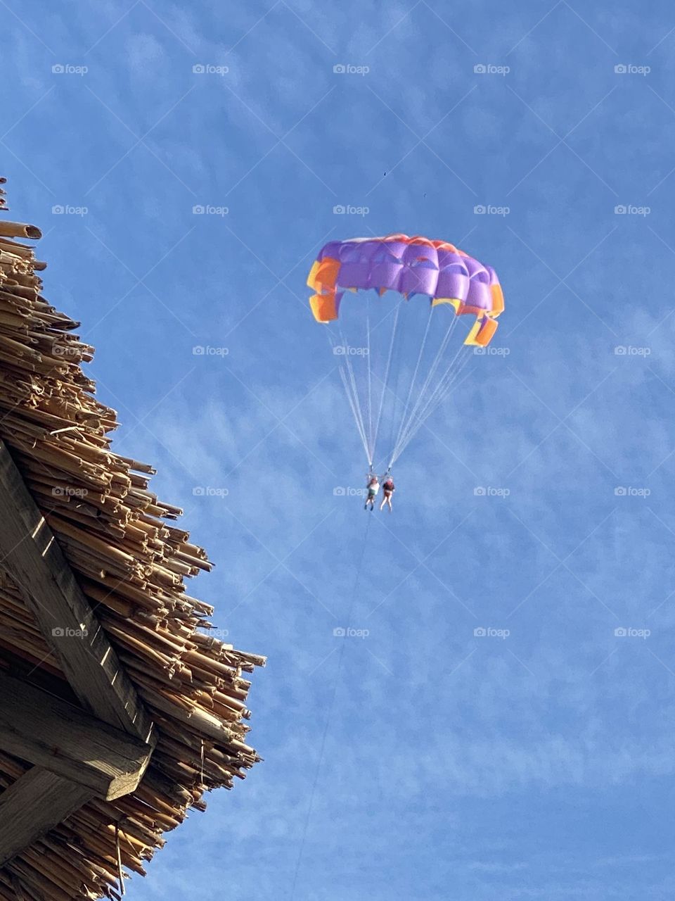 Colourful parachute in the blue sky with white clouds 