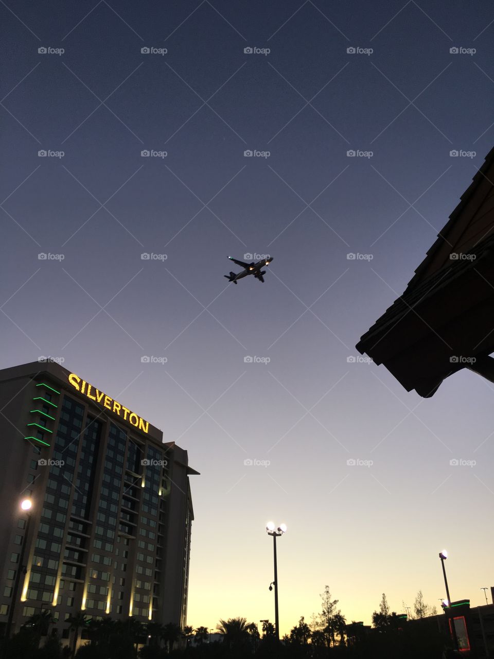 Airplane flying over The Silverton in Las Vegas during sunset