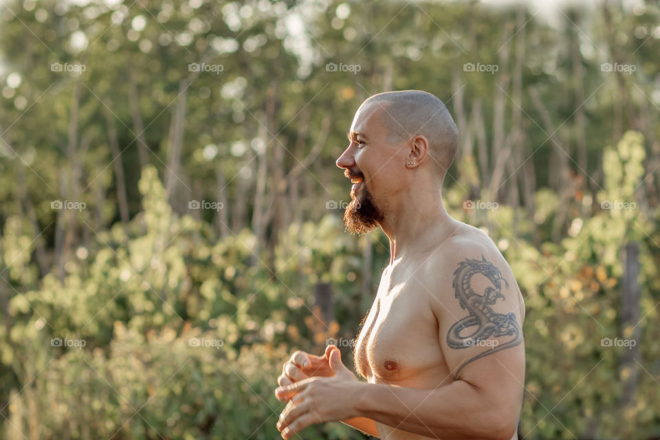 Portrait of happy man with naked torso living in harmony at the countryside. Copy space.