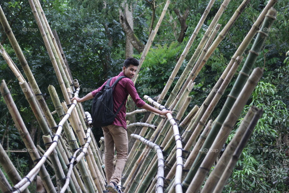 A boy stands on the bamboo shawl