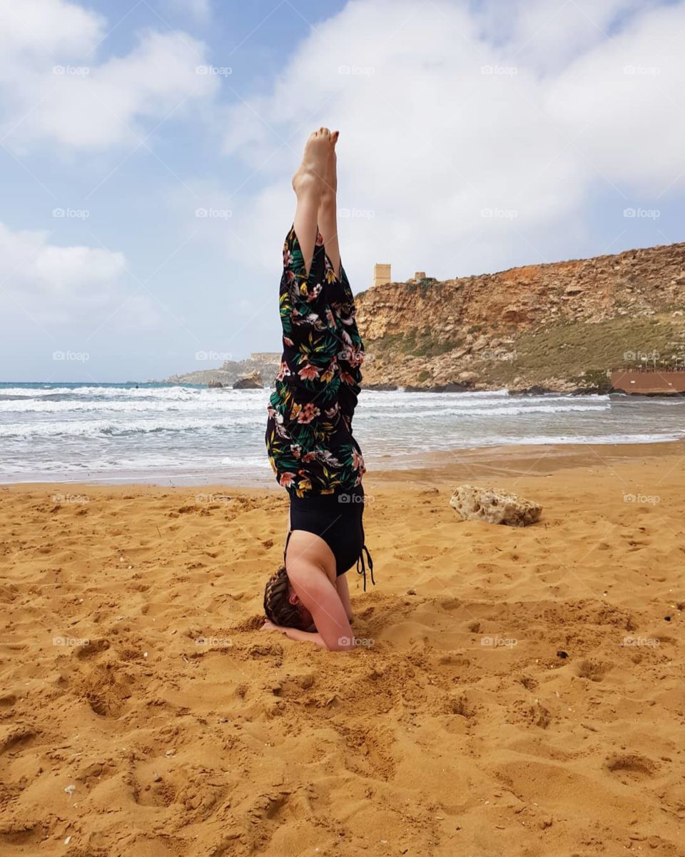 handstand or forearm stand  on beach in malta at Ghajn Tuffieha