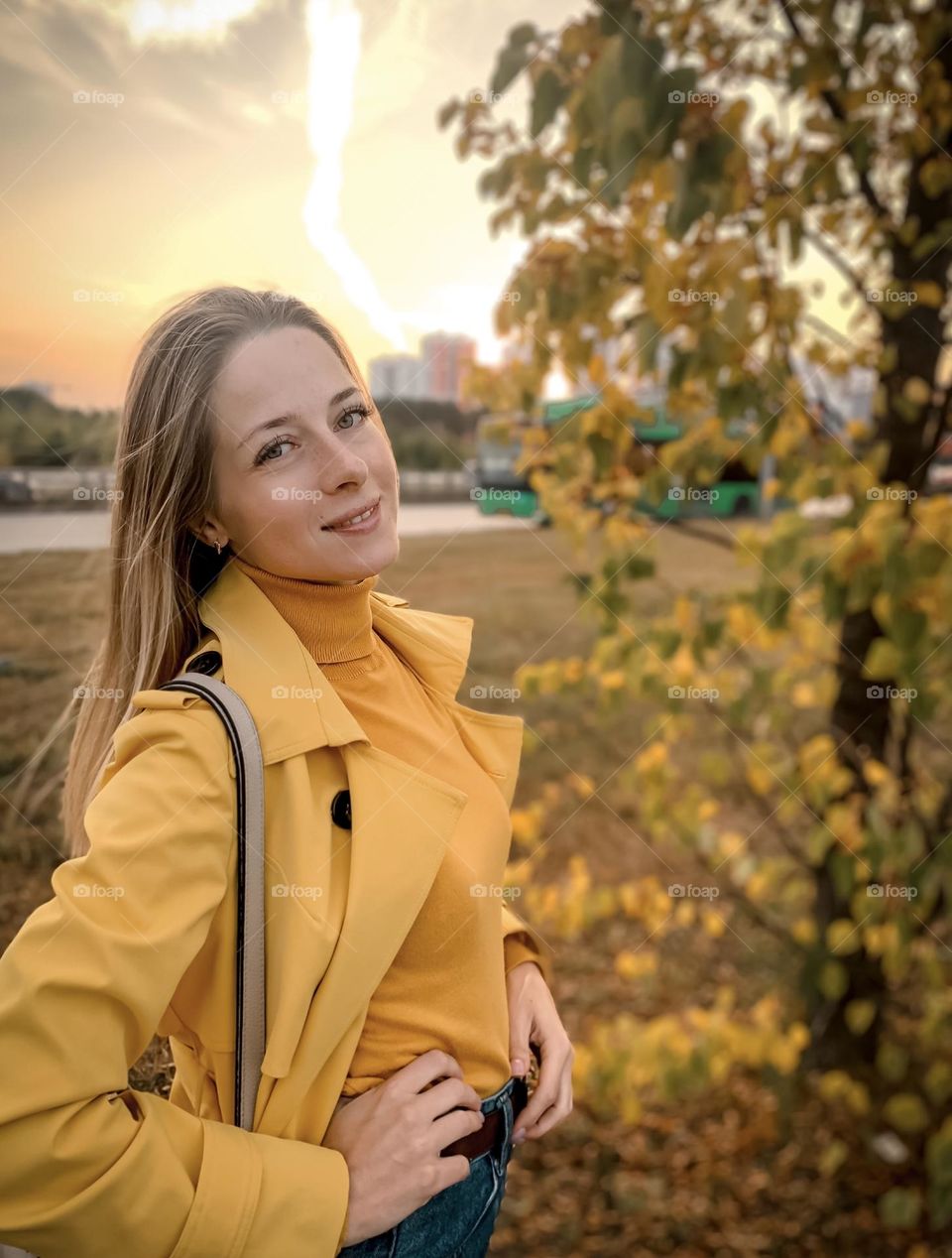 girl in a yellow raincoat in the autumn park