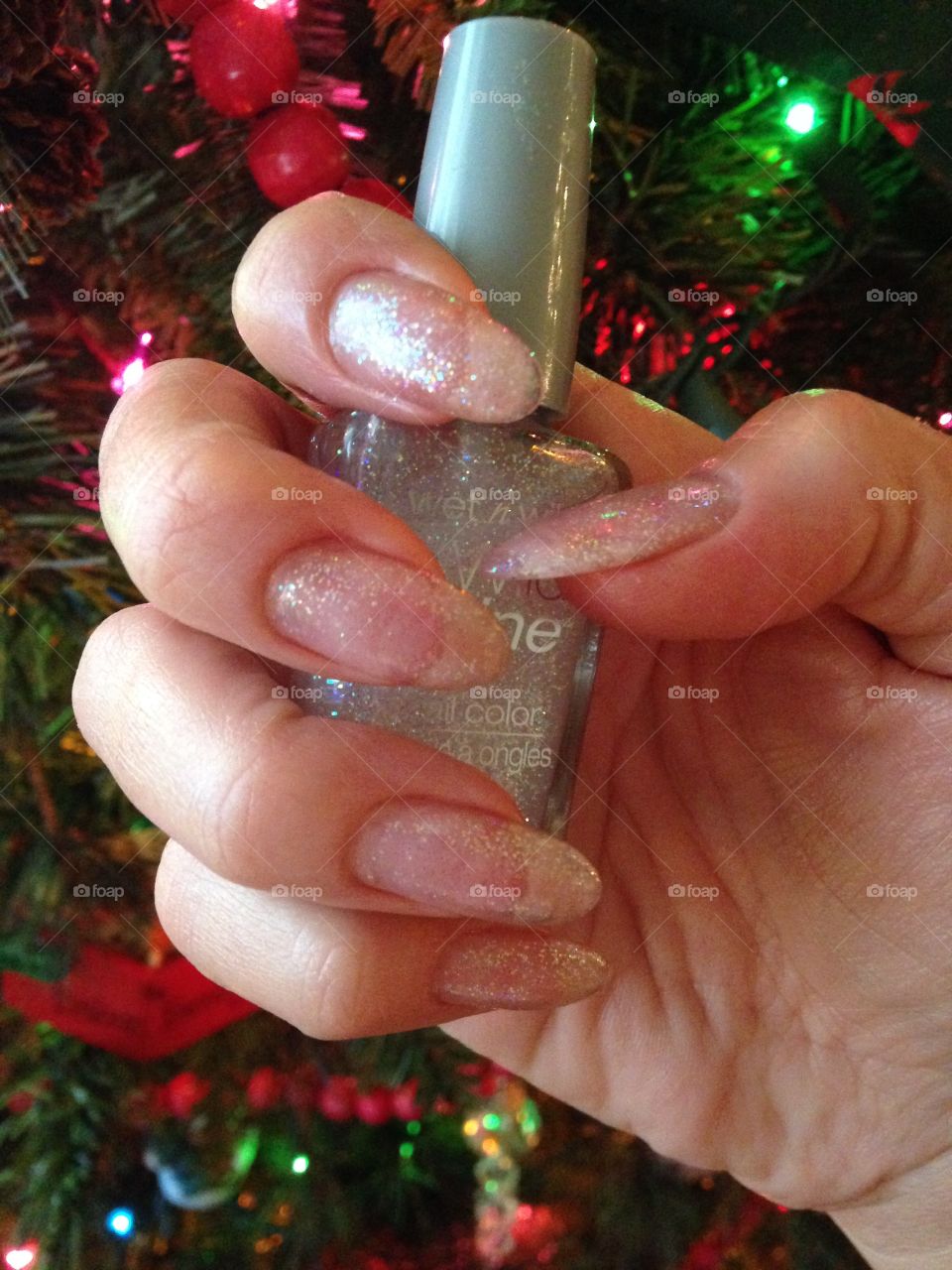 Almond nails with polish bottle and Christmas lights