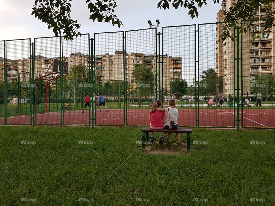 kids holding together on a basketball field