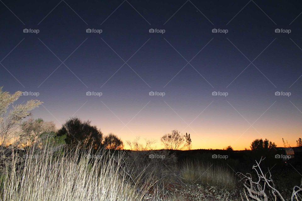 setting sunset in the outback of Australia at an Aussie icon Uluru