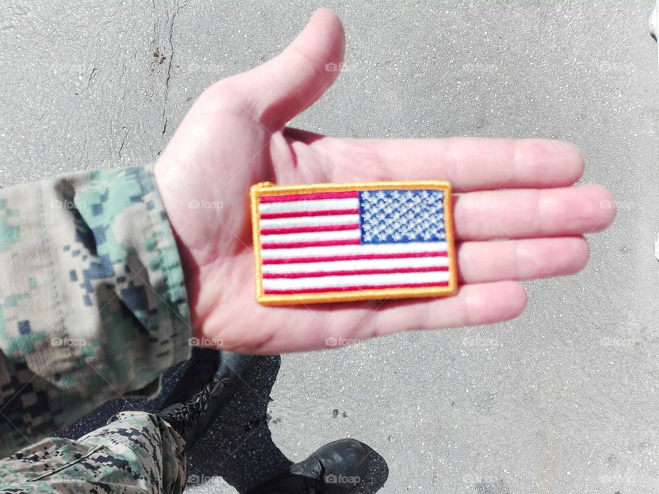a soldier holding the American flag in his hand
