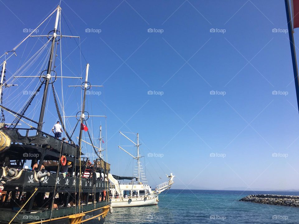 Sunny holidays I’m Turkey. Walk in the cute city and charming streets by the beach in Kusadasi. perfect blue sky and ocean view. Beach and the shore. To travel is to live. Gorgeous tall palm trees.