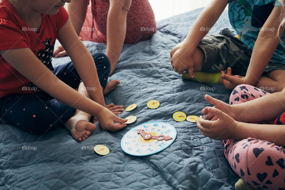 Kids learning how to tell time from clock and set the hands in the correct position. Teaching preschoolers tell time. Candid people, real moments, authentic situations