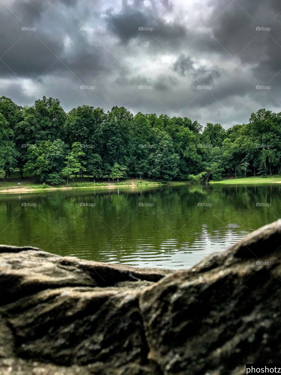 Phoshotz- cloudy lake view from behind a big rock