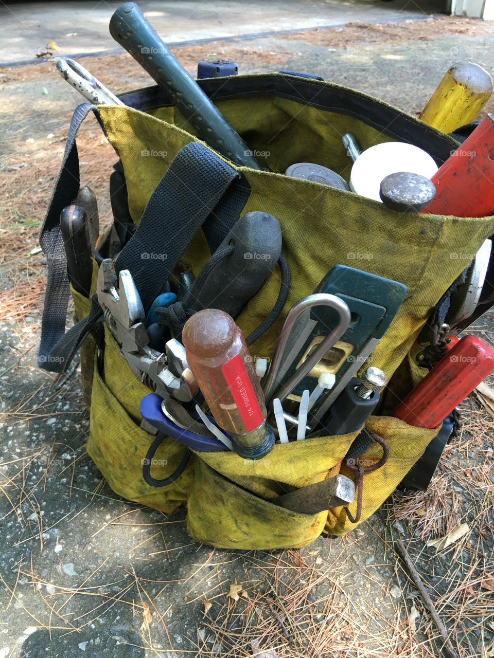 Canvas bucket of tools from above, large variety.
Plumbers employee tools needed for jobs.