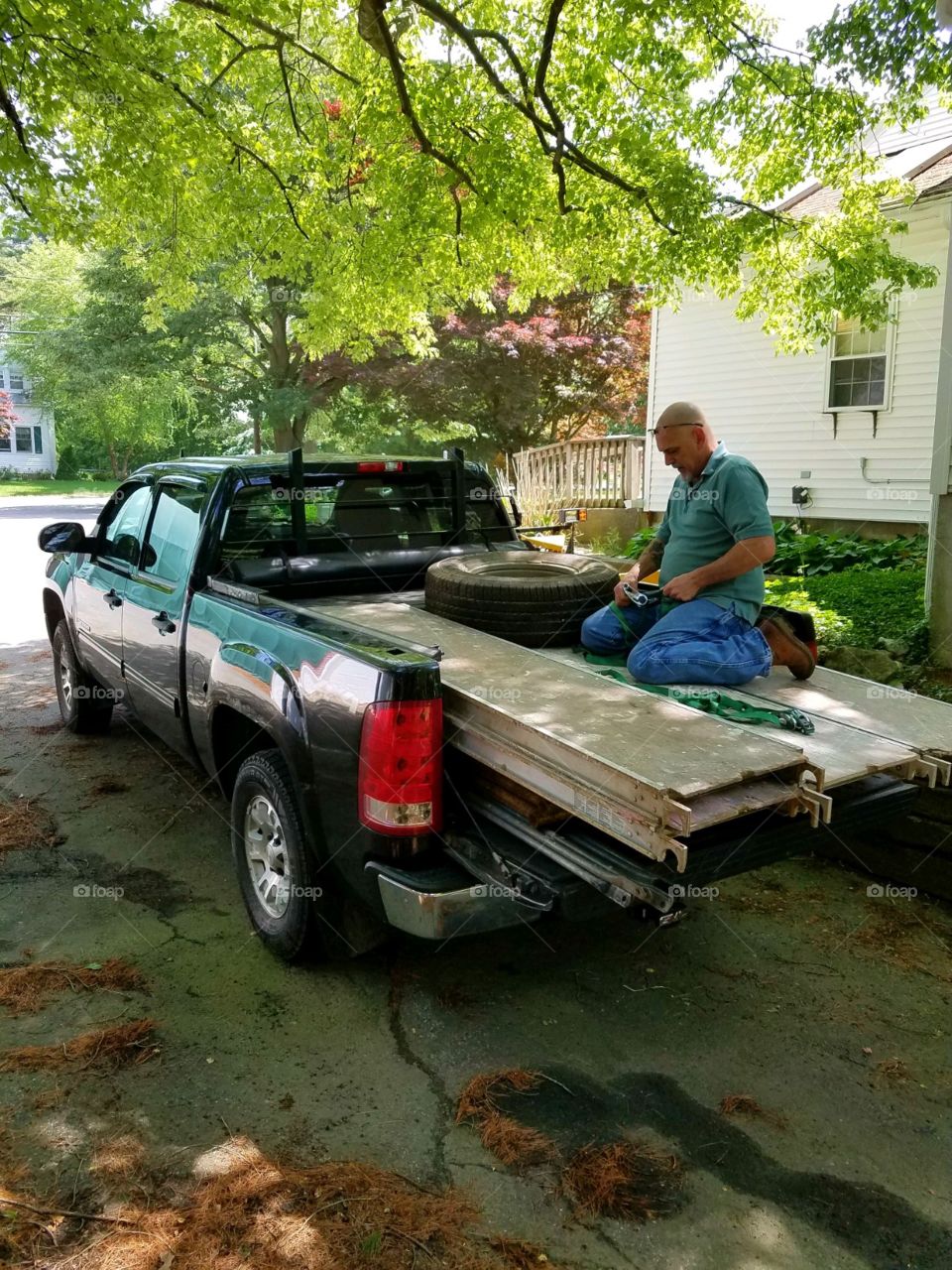Summer activities in USA. A lot of remodeling or construction jobs are done in the summer. Here, staging preparations are started by loading wood into pickup truck.