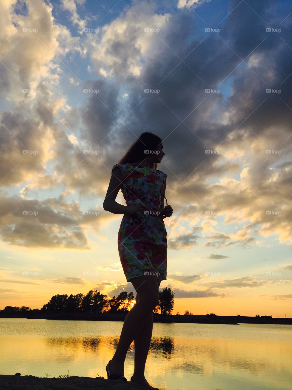 Woman posing near lake during sunset