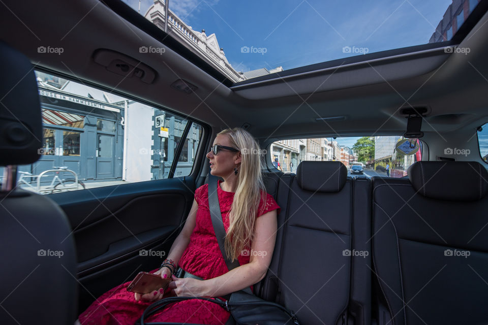 Woman swedish tourist riding a uber taxi in London.