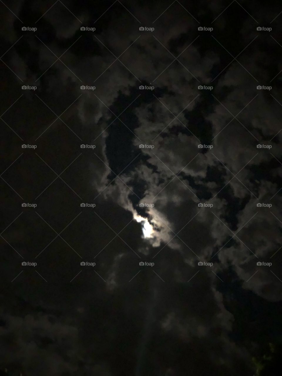 The moon behind clouds