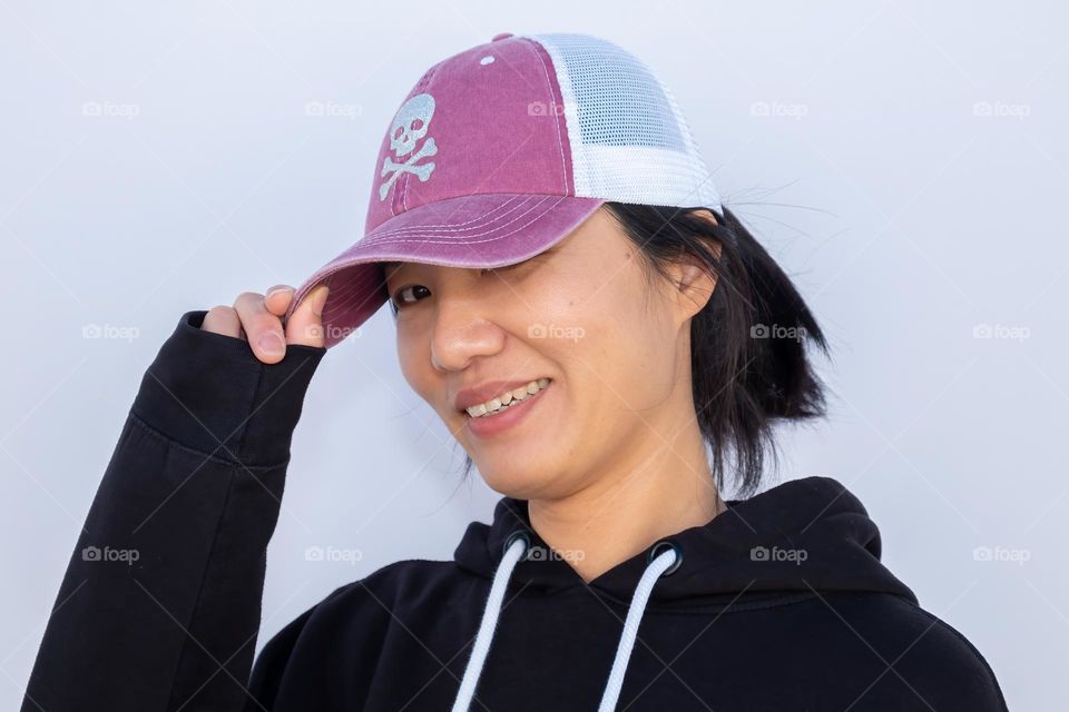 A young lady of Taiwanese descent has fun showing off her sparkly cap. 