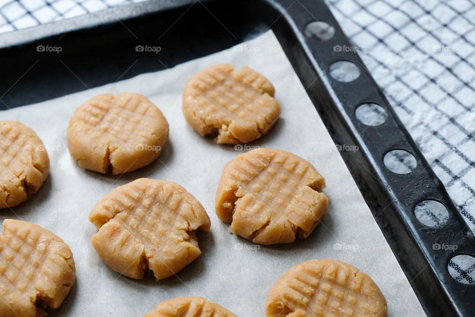Close up of raw American peanut butter cookies on a baking sheet lined with baking paper