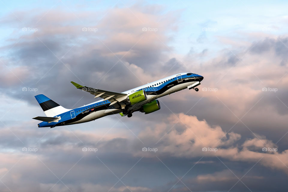 passanger airplane Airbus A220-300 on a sunset sky background