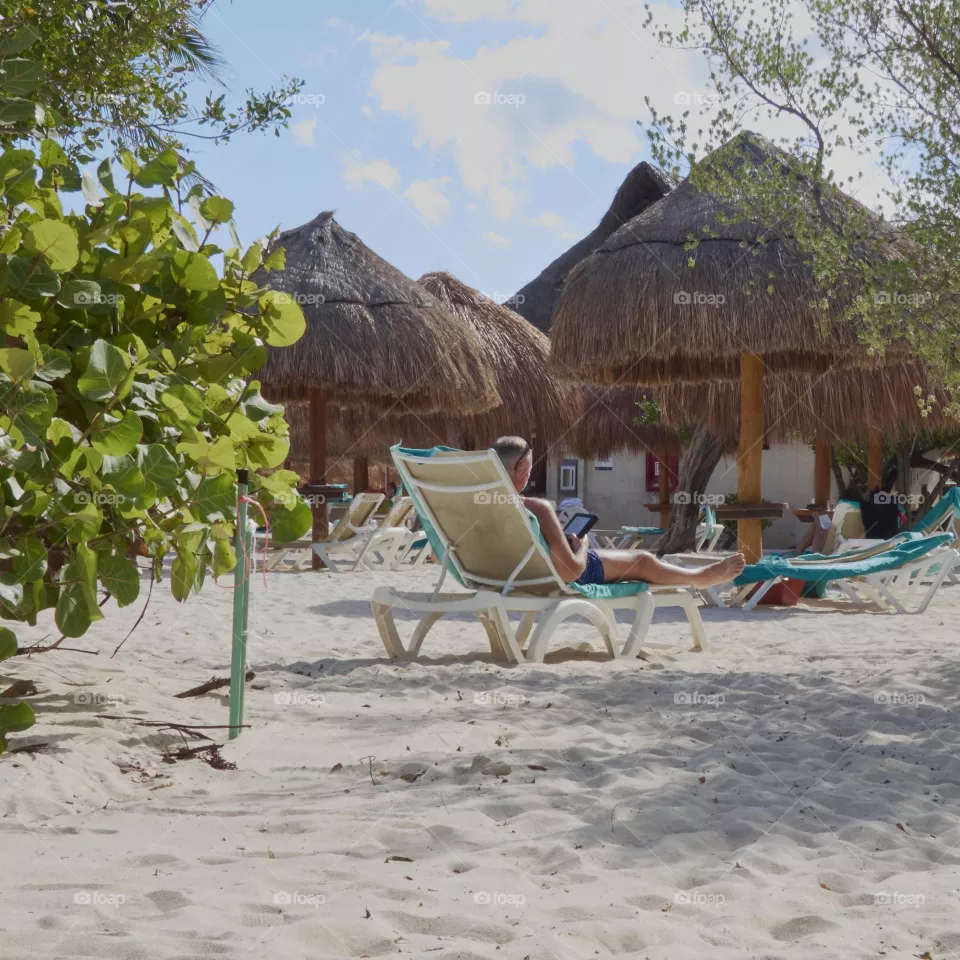 person reading in a hammock on the beach in an e-book