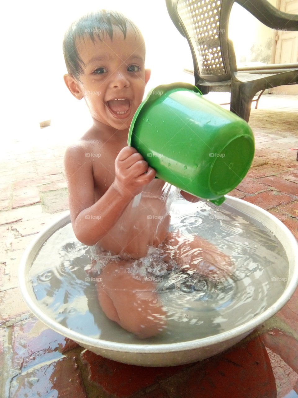 a cute little boy taking bath in a tub.