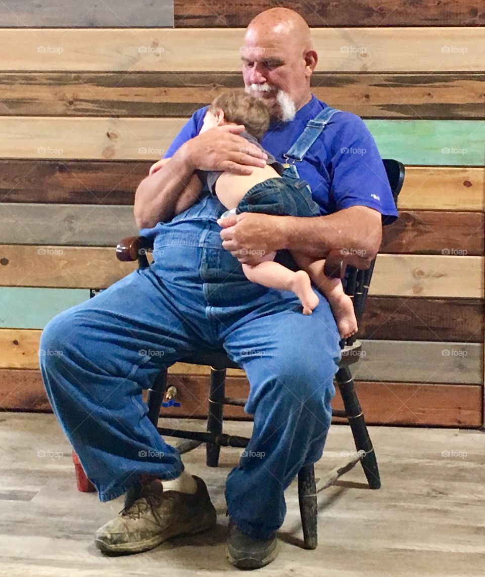 PawPaw in the barn with napping grandson