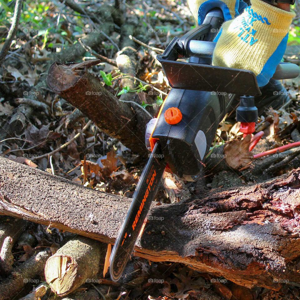 Cutting logs with a Remington electric chainsaw