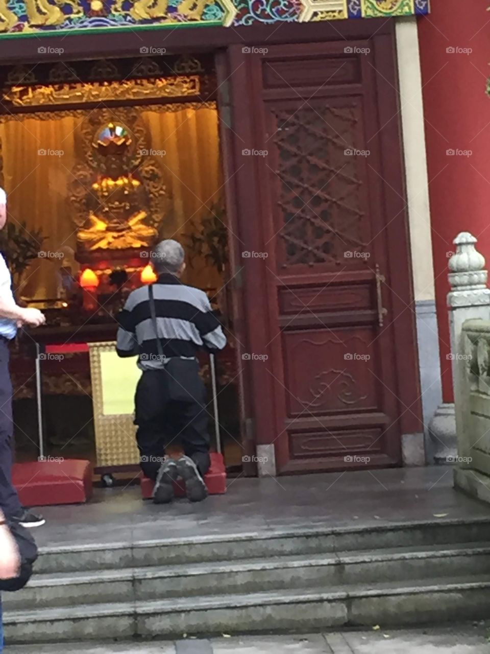 A man praying to Buddha. Buddha Shrine. Ngong Ping Village, Po Lin Monastery, Lantau Island, Hong Kong. 